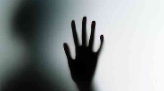 Hand against glass in a silhouette