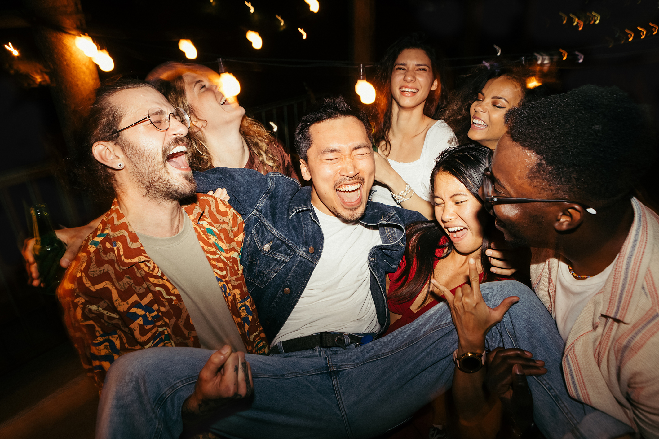 group of friends on a night out, man being picked up in centre of picture