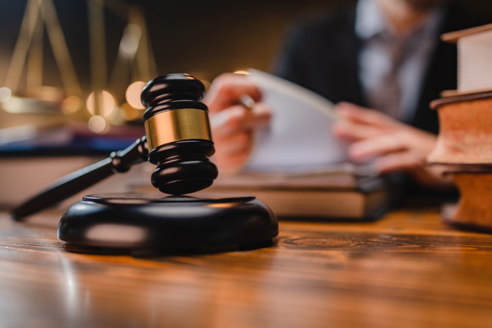 Court hammer with barrister reading papers behind