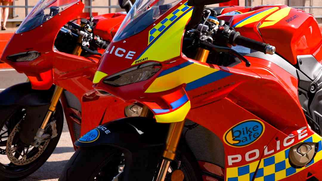 Red Ducati motorcycle with BikeSafe and police stickers.