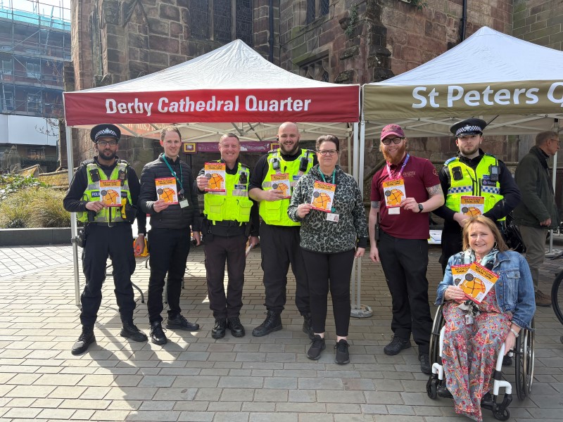 Officers and councillors hold posters with details of the new cycling restrictions.