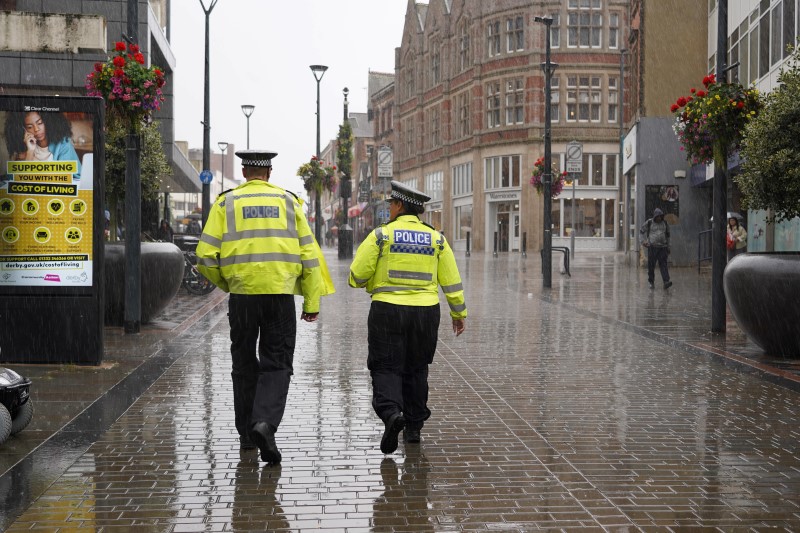 Officers patrol a rainy street in Derby.