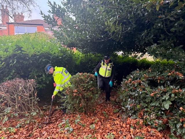2 officers in hi-vis uniforms conducting a knife sweep.