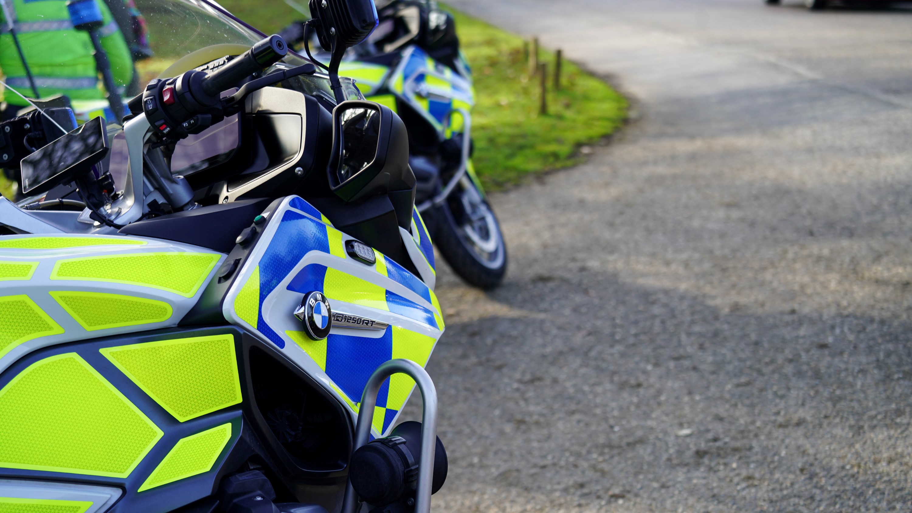 An image of two police motorbikes parked up at the side of a road. 