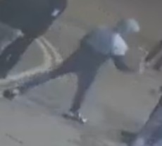 A picture of the back of a person wearing a jacket with their hood up, dark trousers and trainers