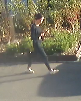 Woman dressed in black clothing walking down a road