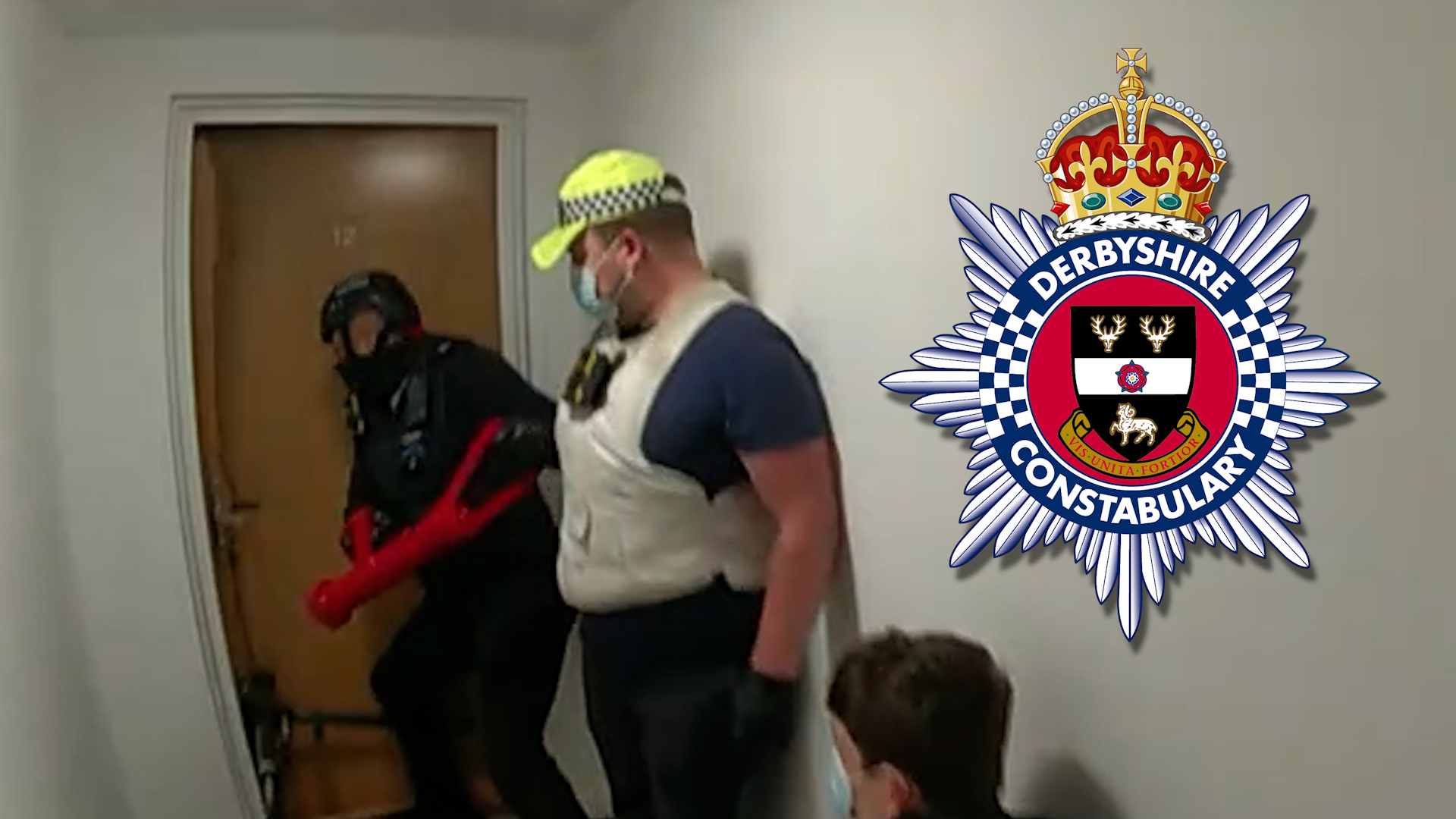 A task force team uses the big red key on a door.