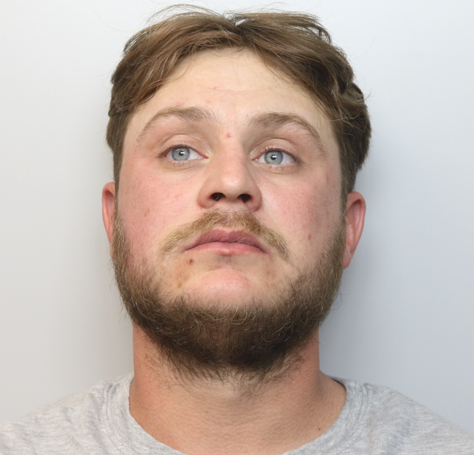 Custody image of Arron Morgan, who is wanted for breaching a Domestic Violence Protection Order.