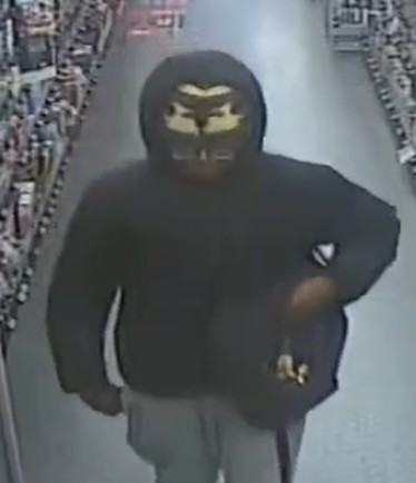 Man wearing a black coat with the hood up and wearing a hat underneath